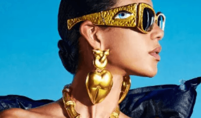 Fashion model with futuristic sunglasses and gold jewelry